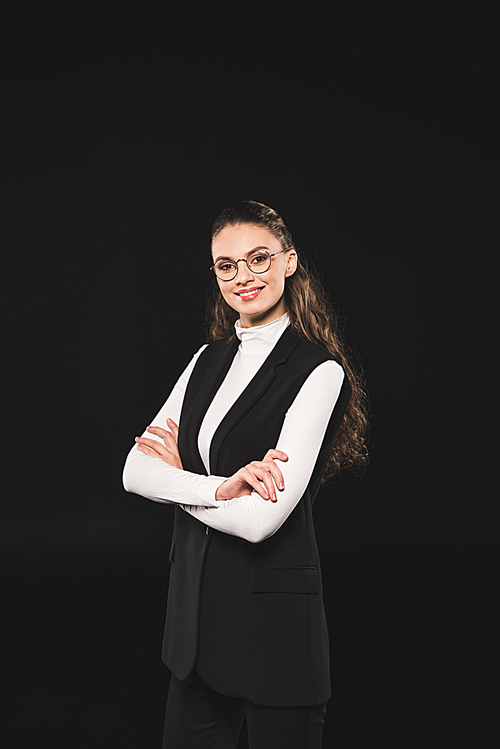 beautiful brunette woman in eyeglasses standing with crossed arms and smiling at camera