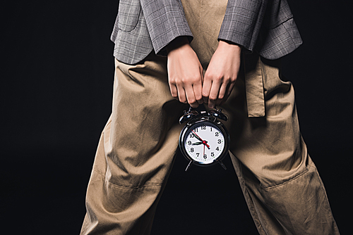 cropped shot of stylish woman holding clock isolated on black