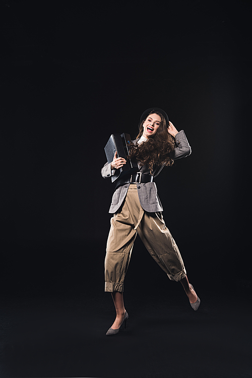 cheerful stylish young woman holding folders and  isolated on black