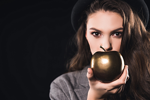 close-up view of young woman holding golden apple and  isolated on black