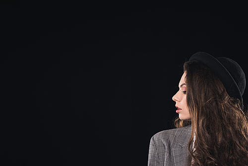 profile of beautiful brunette woman in hat posing isolated on black