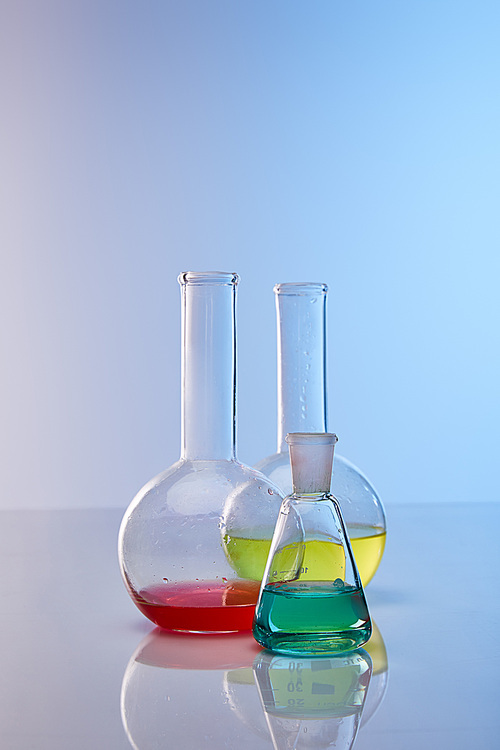 glass flasks with colorful yellow, blue and red liquid