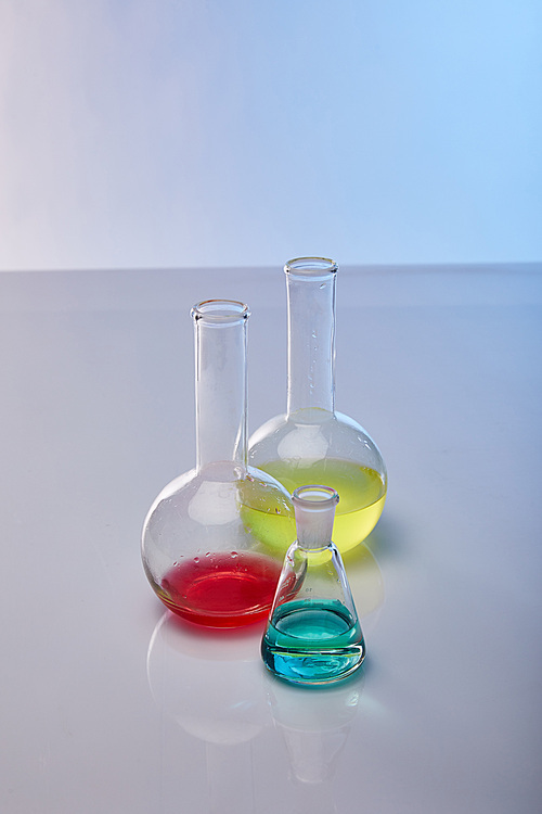 glass flasks with colorful yellow, blue and red liquid