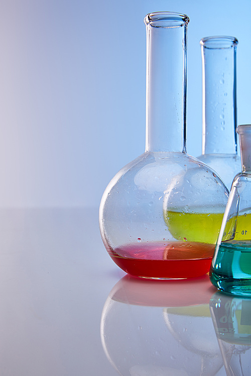 glass flasks with colorful yellow, blue and red liquid