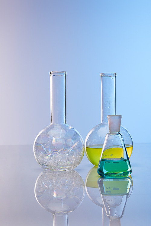 glass flasks with colorful yellow, blue liquid and bubbles