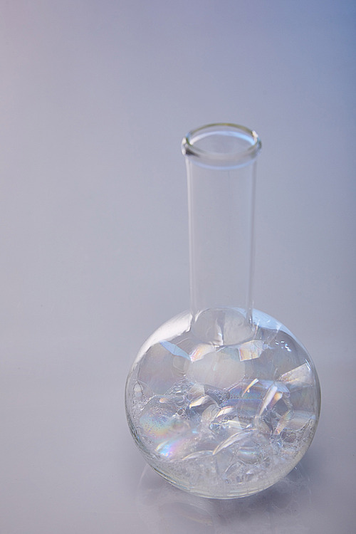 glass flask with bubbles on grey background