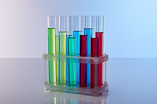 glass test tubes with colorful liquid on blue background