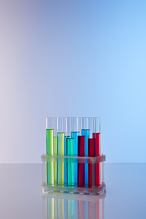 glass test tubes with colorful liquid on blue background