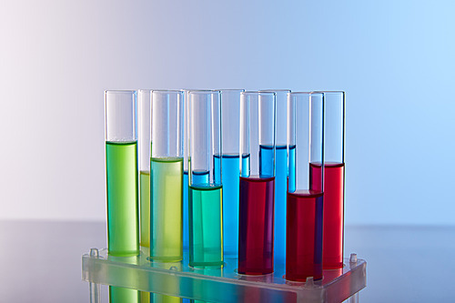 glass test tubes with colorful liquid on blue background