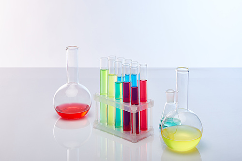 glass test tubes and flasks with colorful liquid isolated on white