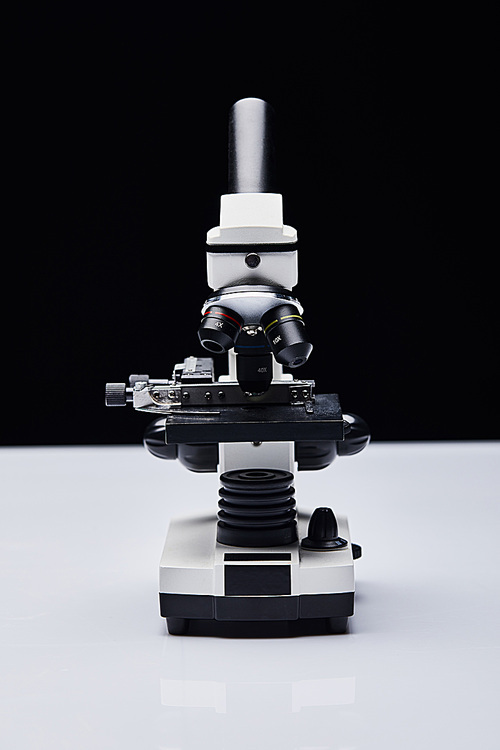 modern microscope on white table isolated on black