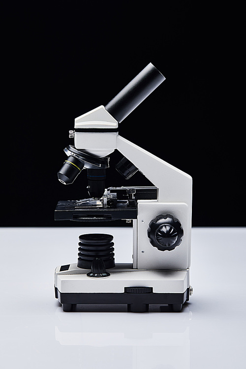 modern microscope on white table isolated on black