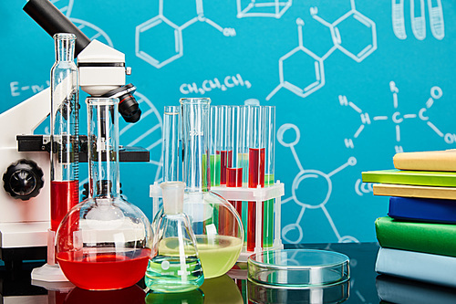 books, microscope, glass test tubes and flasks with colorful liquid on blue background with molecular structure