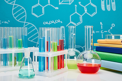 books, glass test tubes and flasks with colorful liquid on blue background with molecular structure