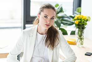 portrait of beautiful businesswoman in white suit  in office