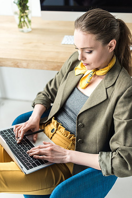 high angle view of stylish businesswoman using laptop in office