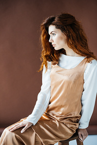 Attractive redhead woman sitting on wooden stool