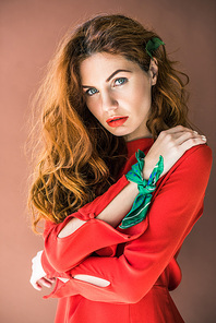 Beautiful young girl in red dress isolated on brown background