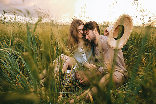 beautiful stylish couple hugging in green grass on meadow