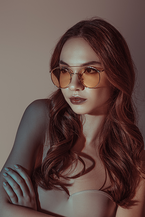 attractive girl posing in yellow sunglasses, isolated on grey