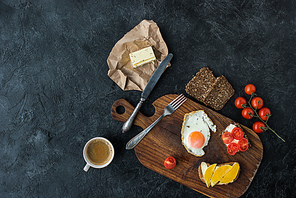 flat lay with tasty healthy breakfast on wooden cutting board on dark tabletop