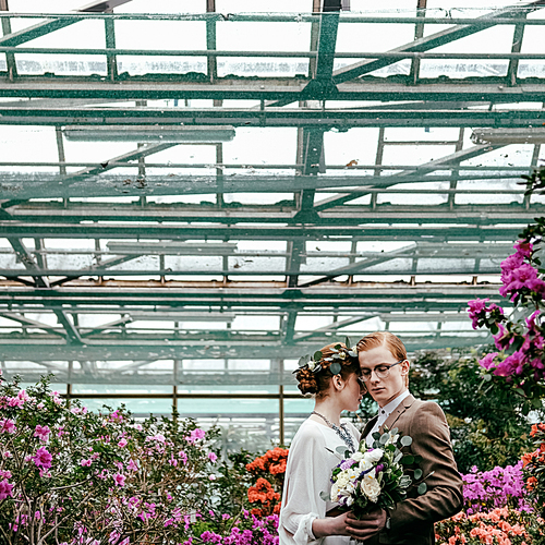 romantic bride and groom hugging each other in greenhouse
