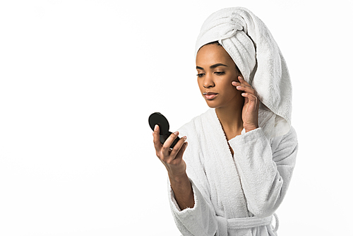 african american woman in bathrobe and towel looking at mirror,  isolated on white