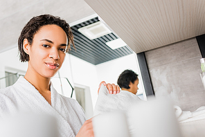 beautiful african american girl taking towel in bathroom