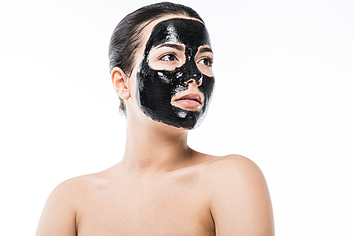 beautiful girl in cosmetic black clay facial mask looking away isolated on white