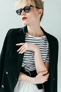 Stylish pretty woman wearing black and white clothes isolated on grey