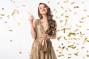 smiling attractive woman standing with champagne under falling confetti isolated on white