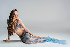 beautiful woman with mermaid tail lying on floor and 