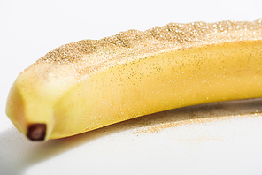 one ripe banana with glitter on white