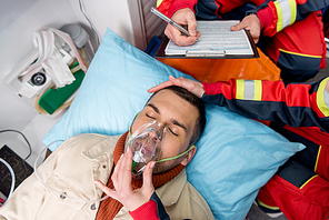 Top view of unconscious patient in oxygen mask