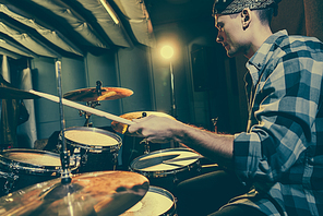 selective focus of drummer holding drum sticks while playing drums