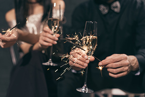 selective focus of couple with glasses of champagne and sparkles at christmas party