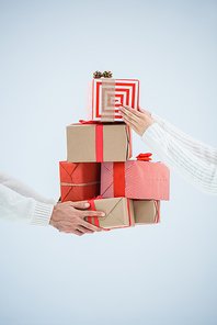cropped shot of couple holding stack of wrapped christmas gifts isolated on grey