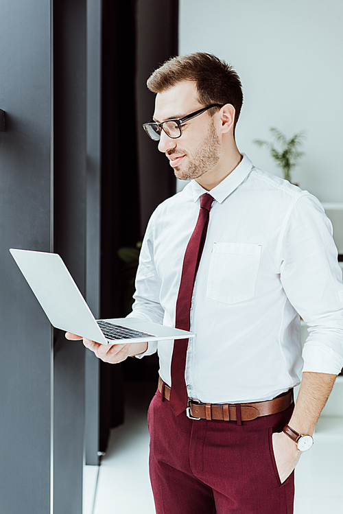 stylish businessman using laptop in modern office