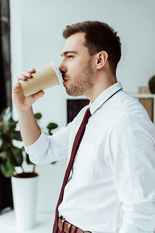 businessman drinking coffee from disposable cup