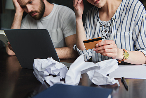 cropped shot of young couple counting bills together