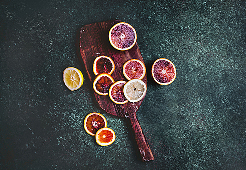 top view of cutting board with slices of blood orange and lemon on table
