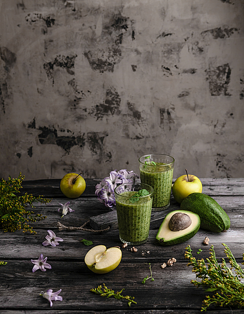 Organic fruit smoothie on wooden background with fruits and flowers