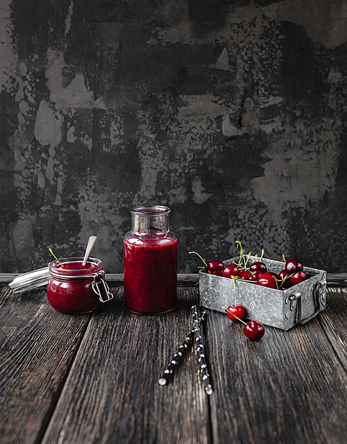 Fresh healthy smoothie on rustic table with cherries and straws