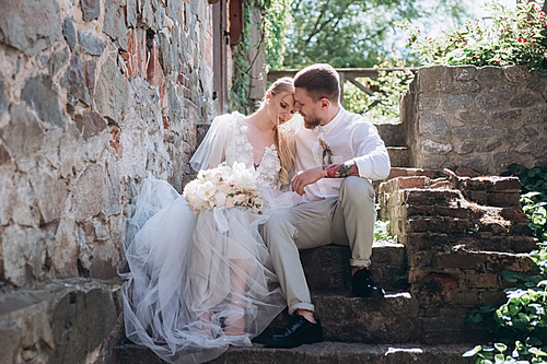 bride and groom sitting on stairs at old town