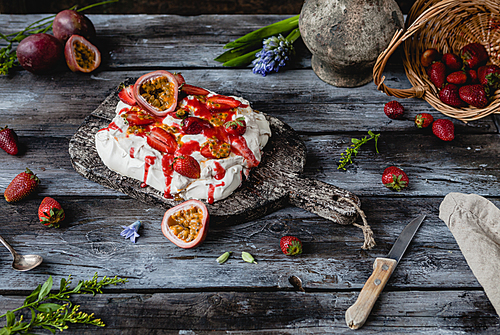 tasty strawberry and passion fruit meringue cake on wooden table