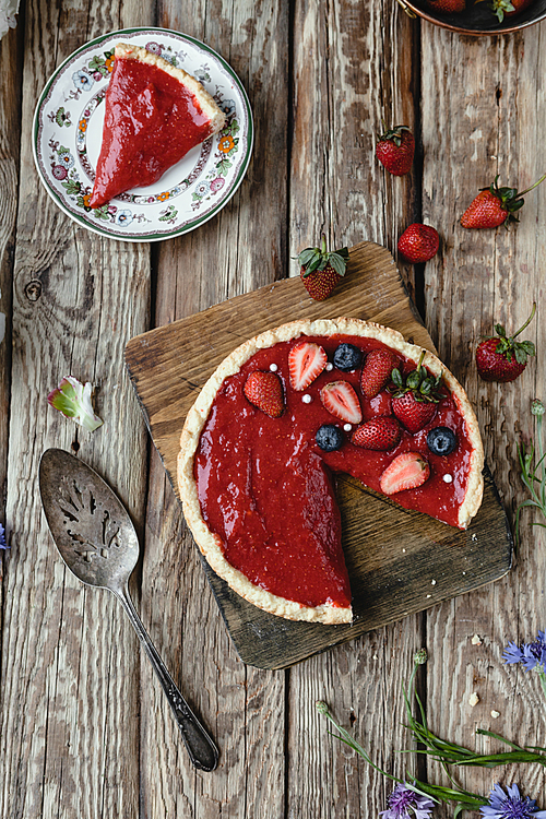 top view of delicious red strawberry pie on wooden table