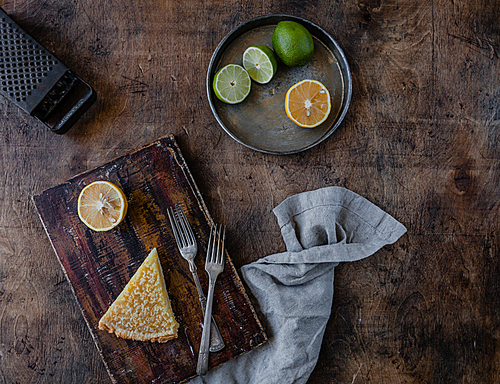 top view of tasty lemon pie on cutting board and fruits on plate