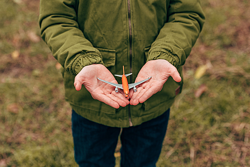 close-up partial view of little boy holding toy plane