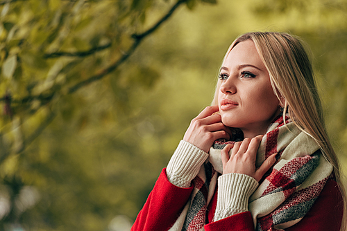 beautiful young woman looking away in autumn park