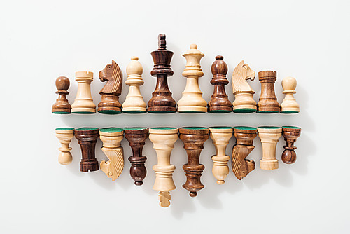 top view of rows made of wooden chess figures on white background